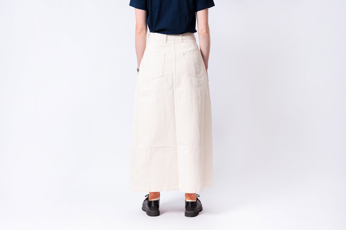 Person wearing a navy shirt and beige wide-leg pants on a white background