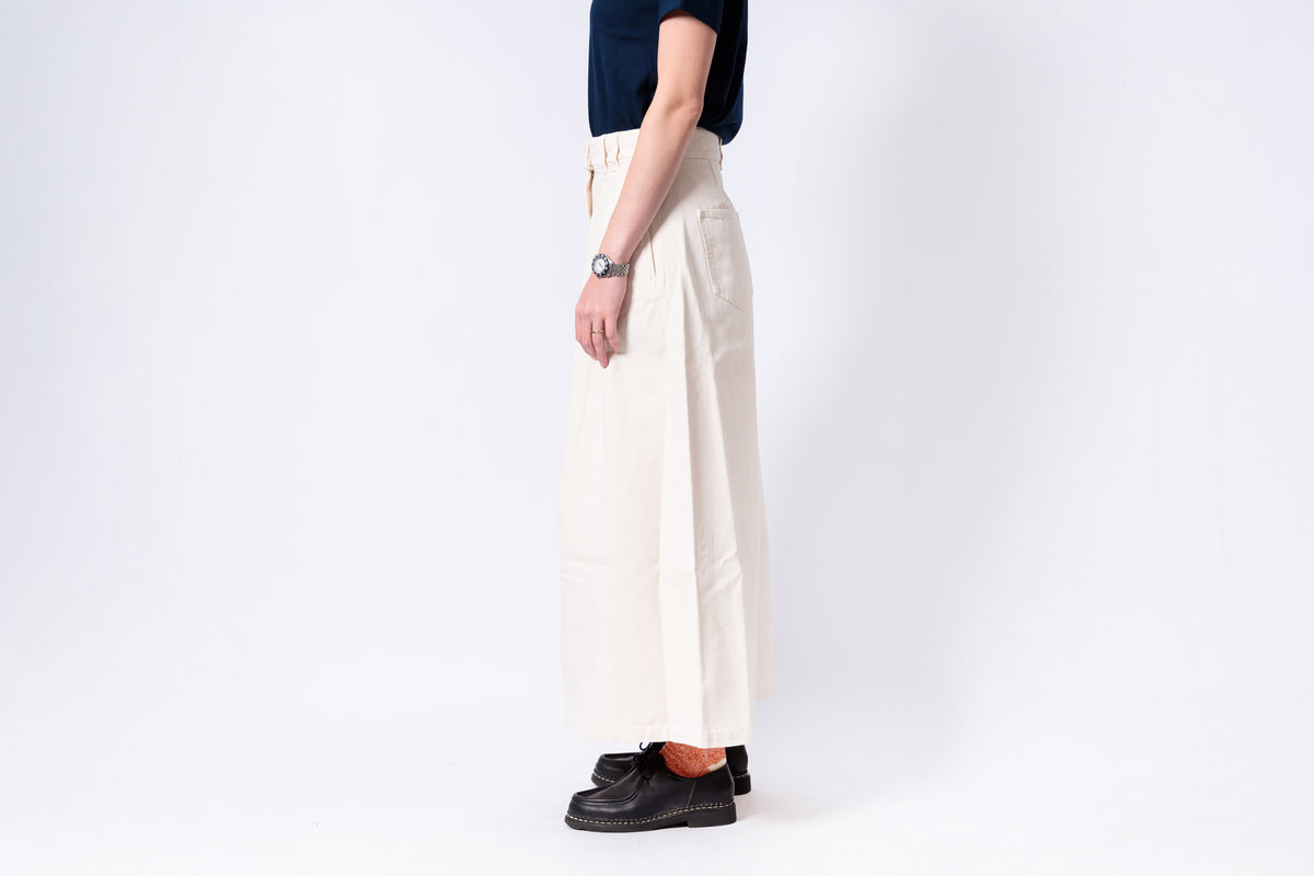 Person wearing white pants and black shoes on a white background