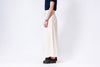 Person wearing white pants and black shoes on a white background