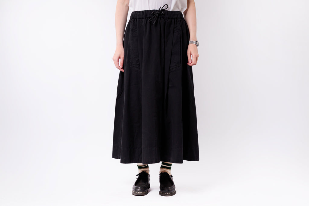 Person wearing a black skirt on a white background