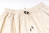 Close-up of beige shorts with drawstring on a white background
