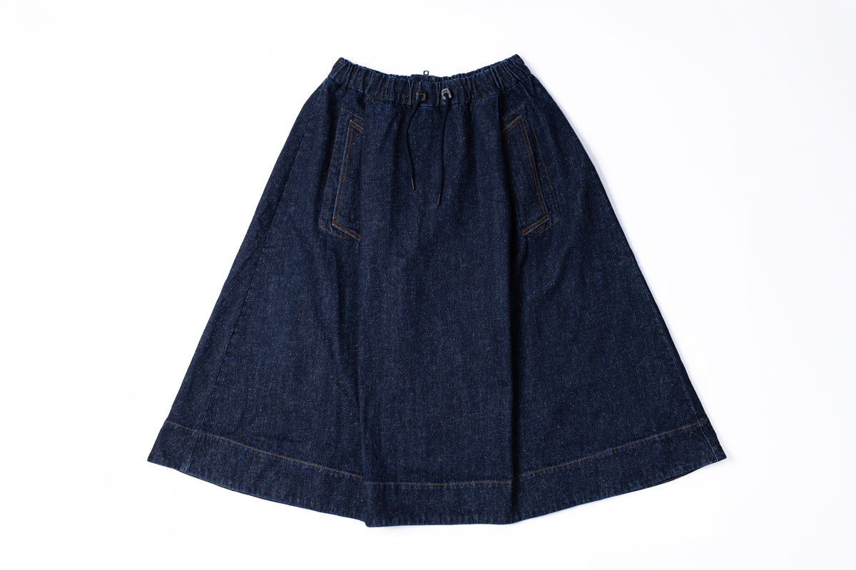 A dark indigo denim A-line skirt with an elastic waistband and two front patch pockets, laid flat on a white background.