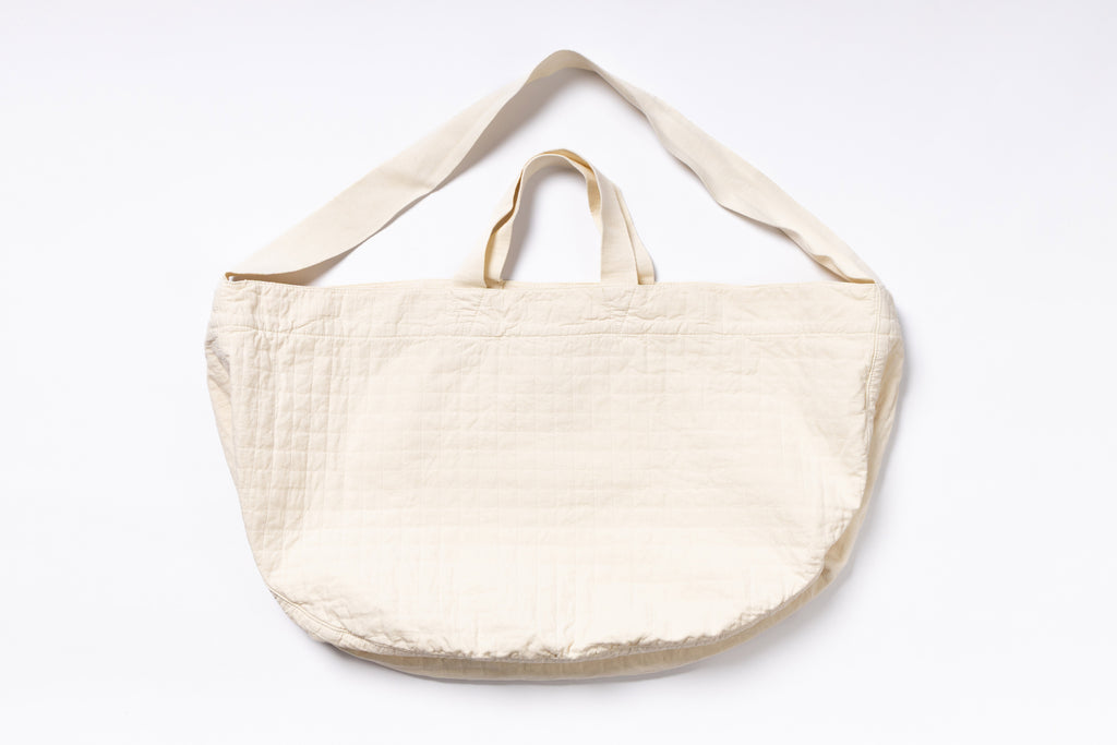 Beige tote bag with shoulder strap on a white background