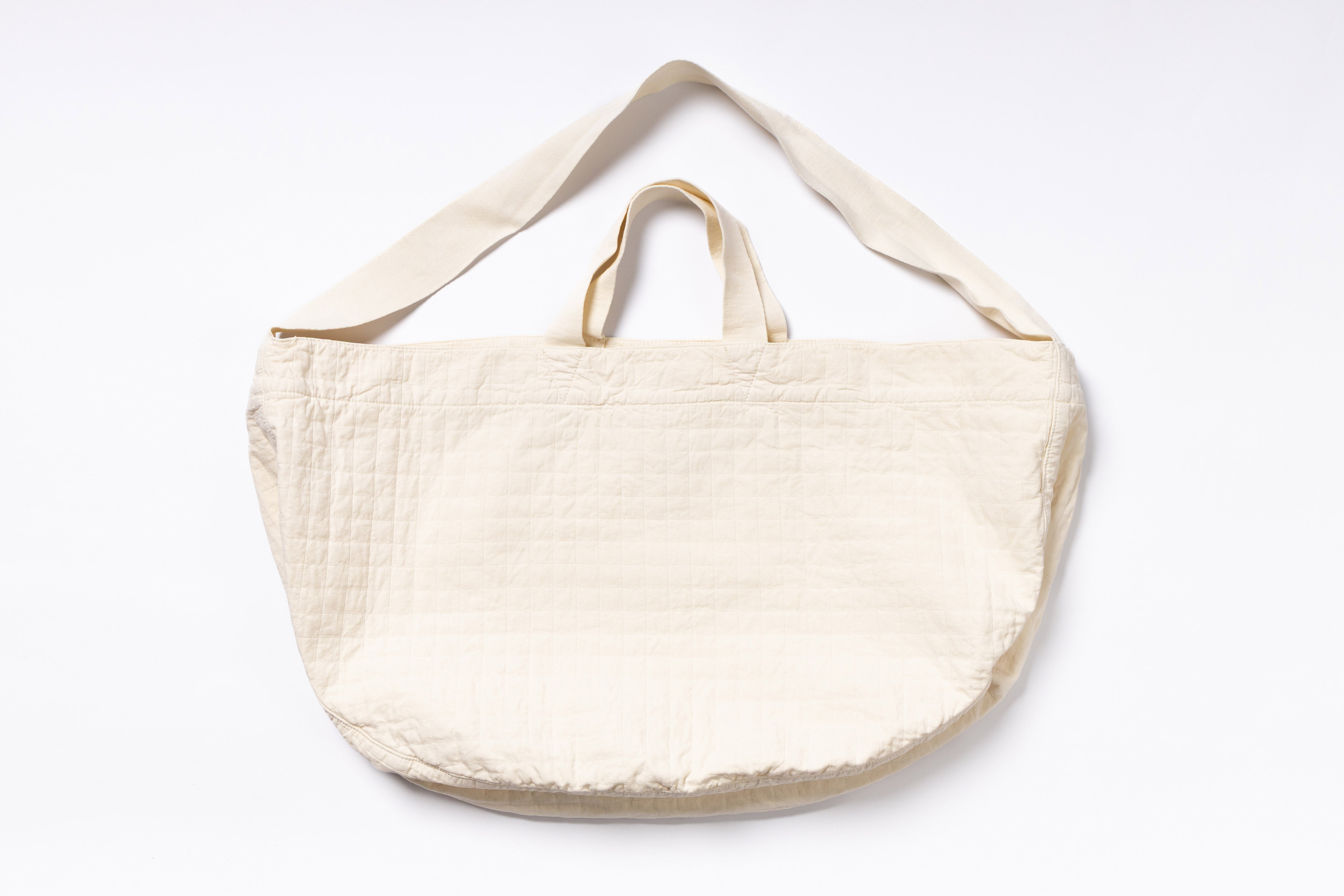 Beige tote bag with shoulder strap on a white background