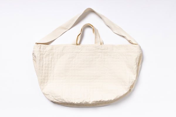 Beige tote bag with shoulder strap on a white background