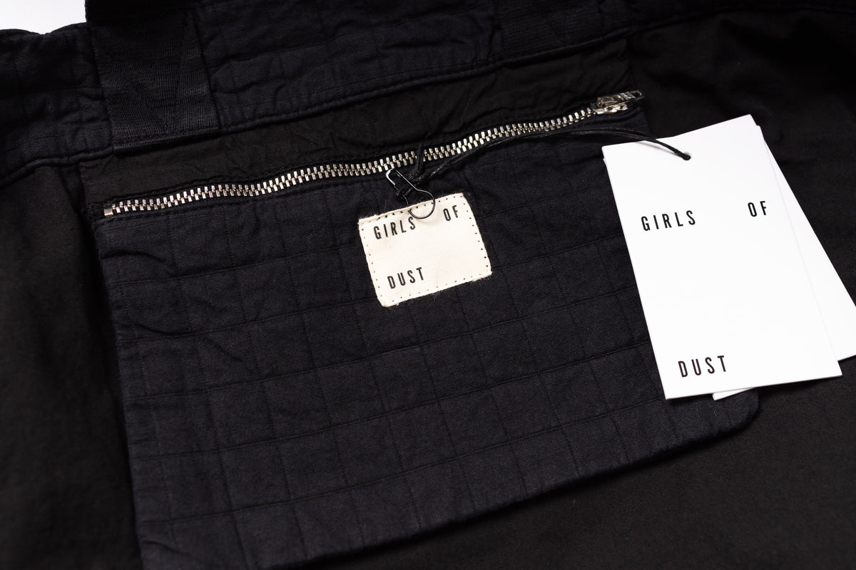 Black jacket with a brand tag and paper on a black background