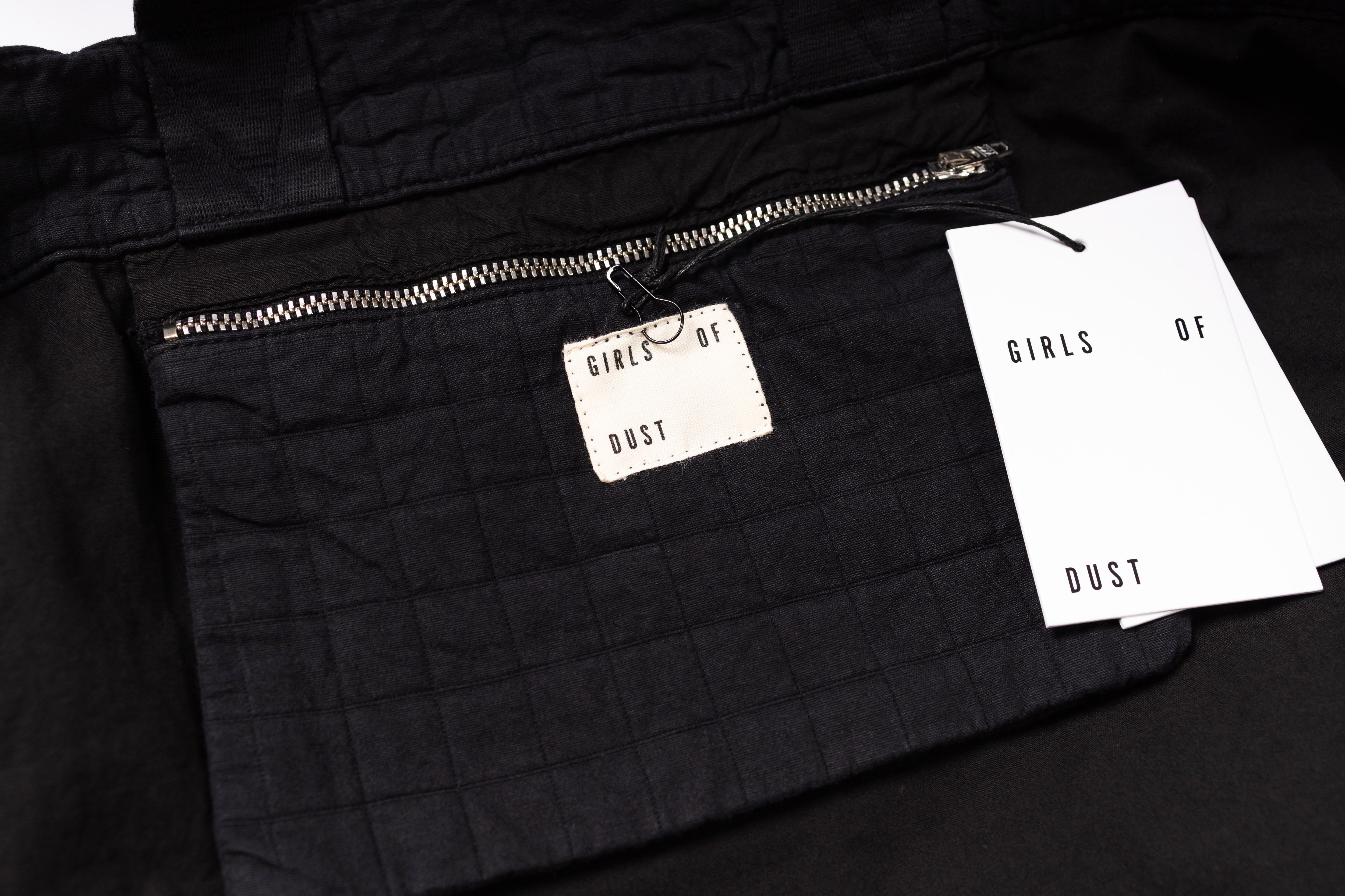 Black jacket with a brand tag and paper on a black background