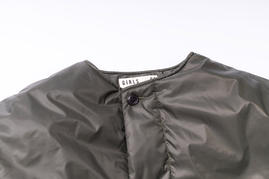 Close-up of a gray jacket with a brand label on a white background