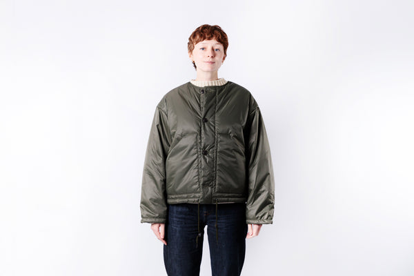 Person wearing a green jacket on a white background
