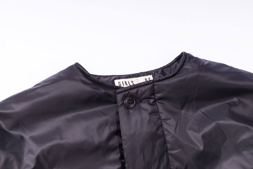 Close-up of a dark gray jacket with a brand label on a white background