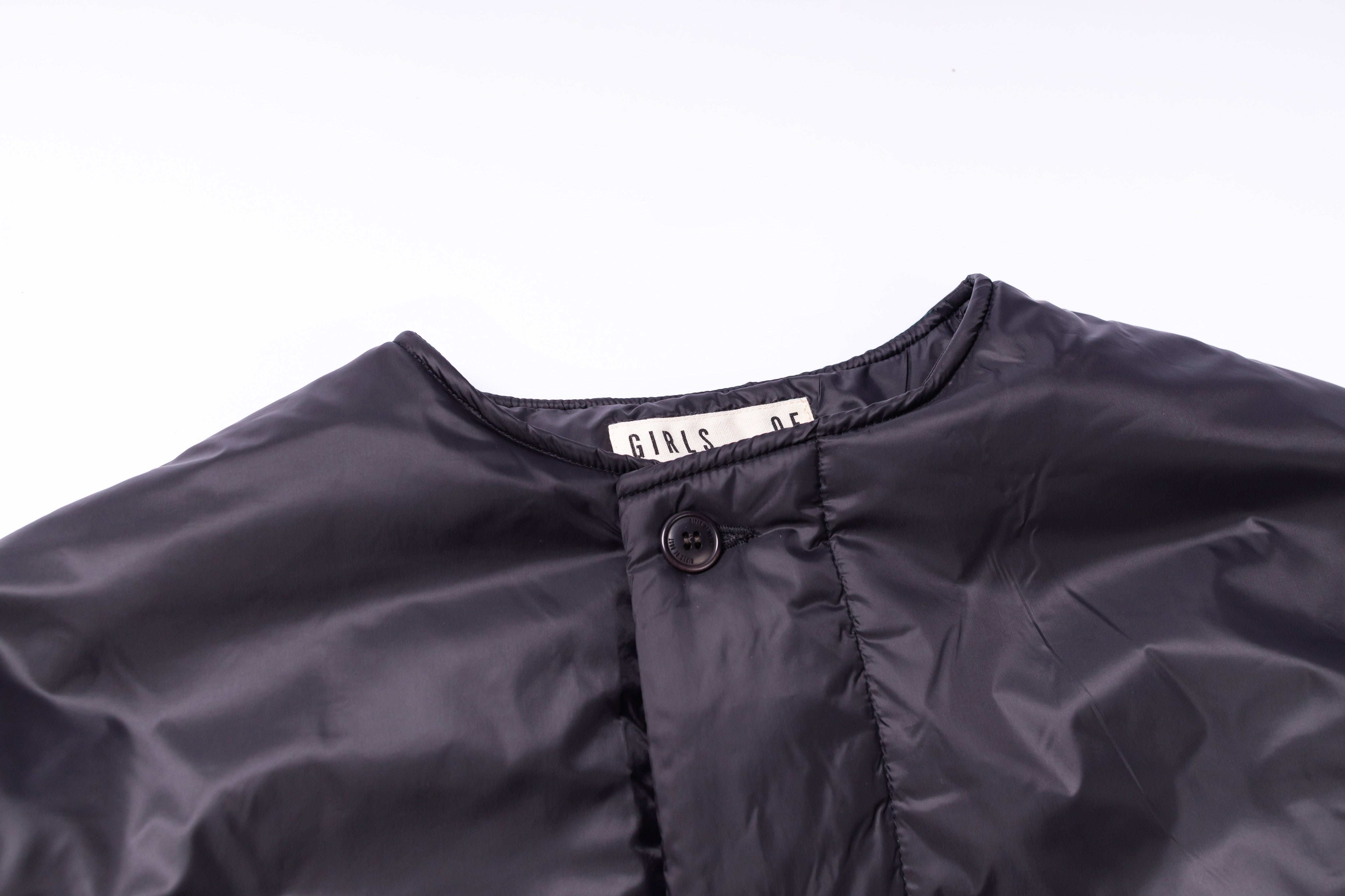 Close-up of a dark gray jacket with a brand label on a white background