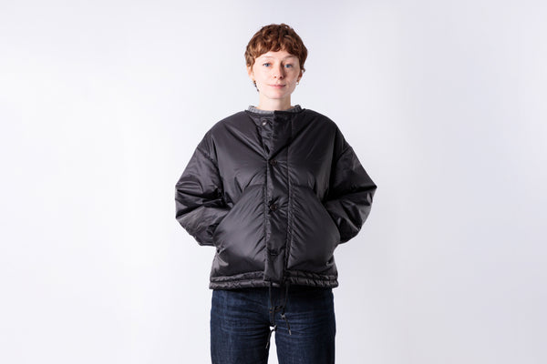 Person wearing a black puffer jacket on a white background