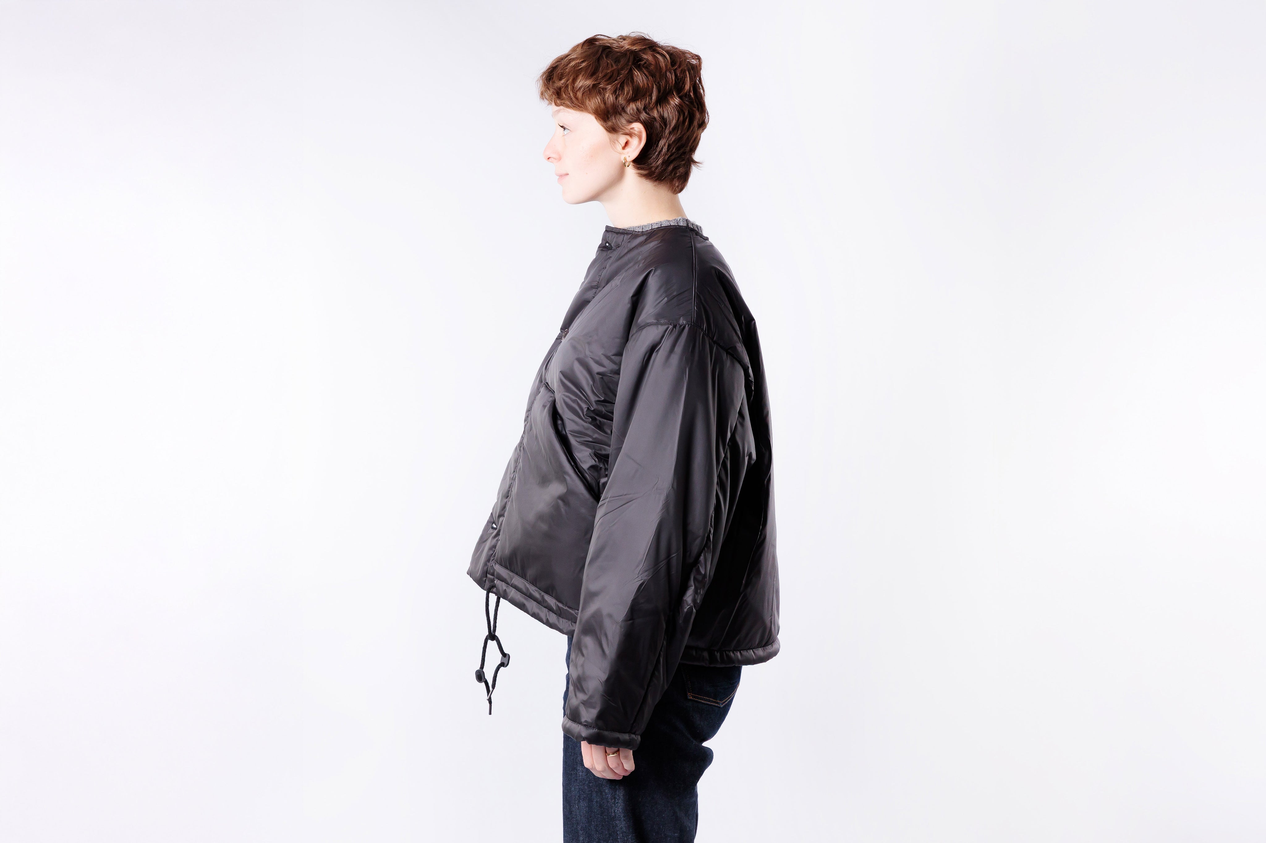 Person wearing a dark gray jacket on a white background