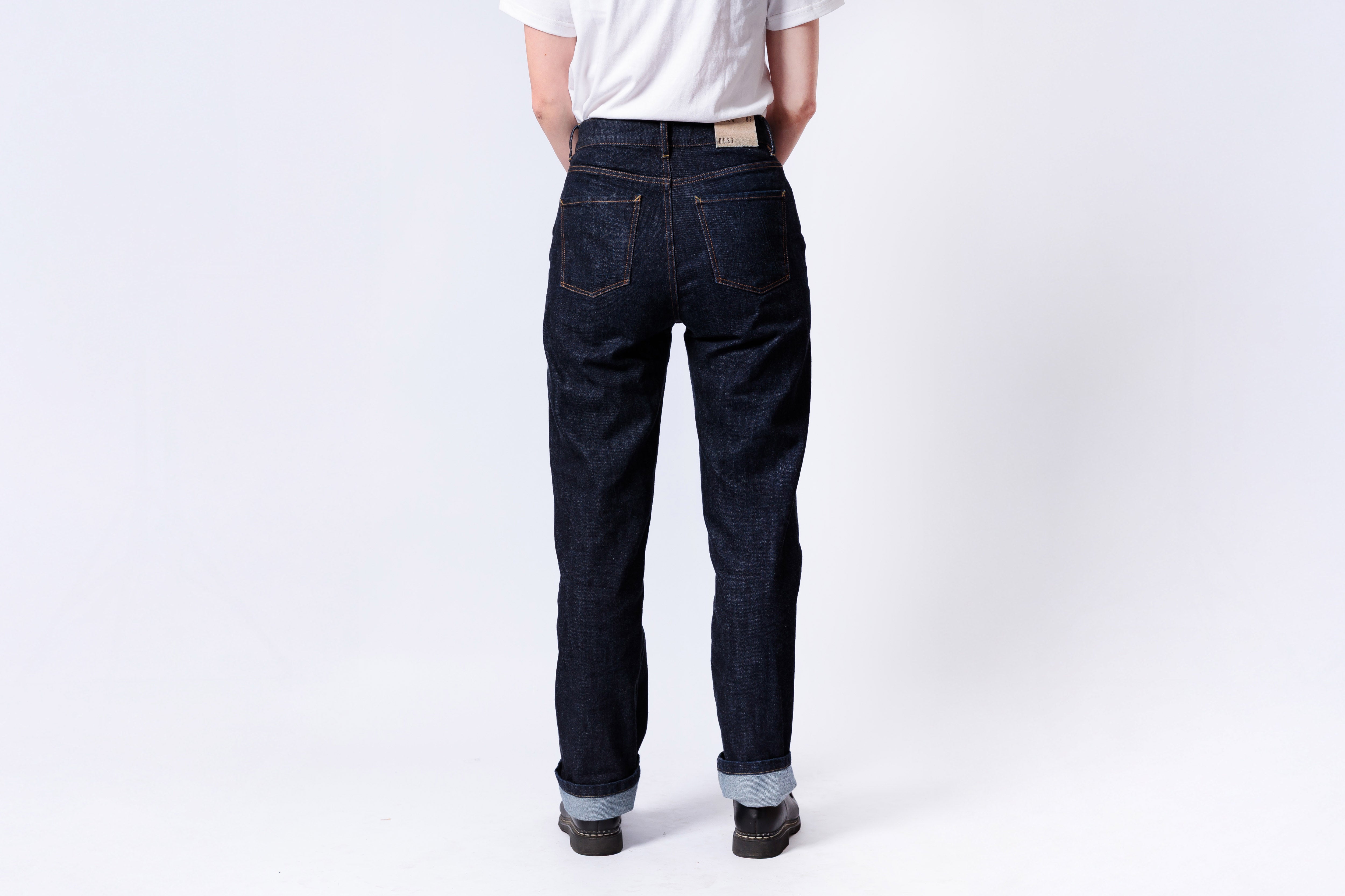 Person wearing dark blue jeans and a white shirt on a white background