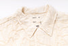Close-up of a textured cream-colored fabric with 'Girls of Dust' branding.