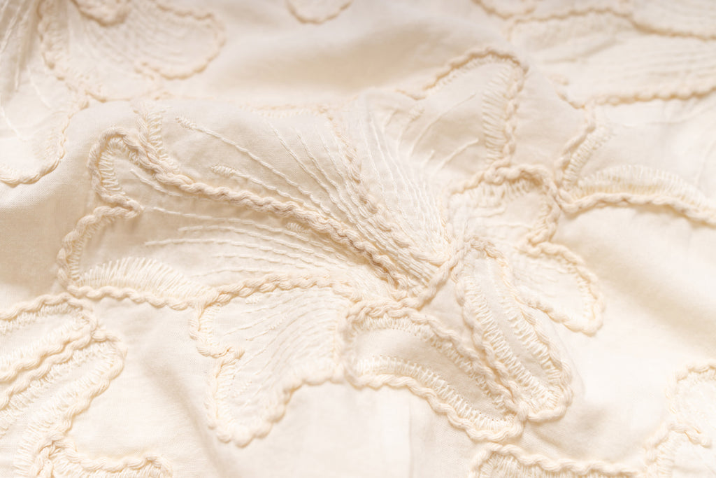 Close-up of textured beige fabric with floral pattern