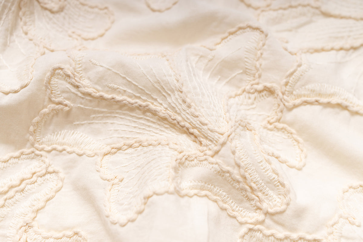 Close-up of textured beige fabric with floral pattern