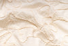 Close-up of textured beige fabric with floral pattern