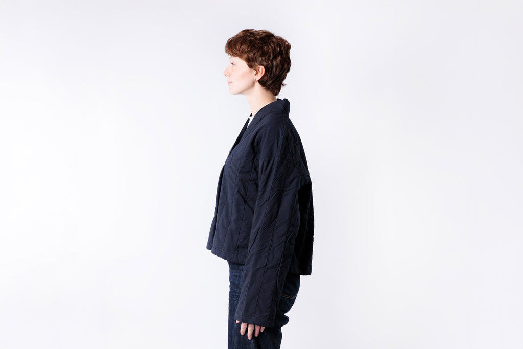 Person wearing a dark blue jacket on a white background