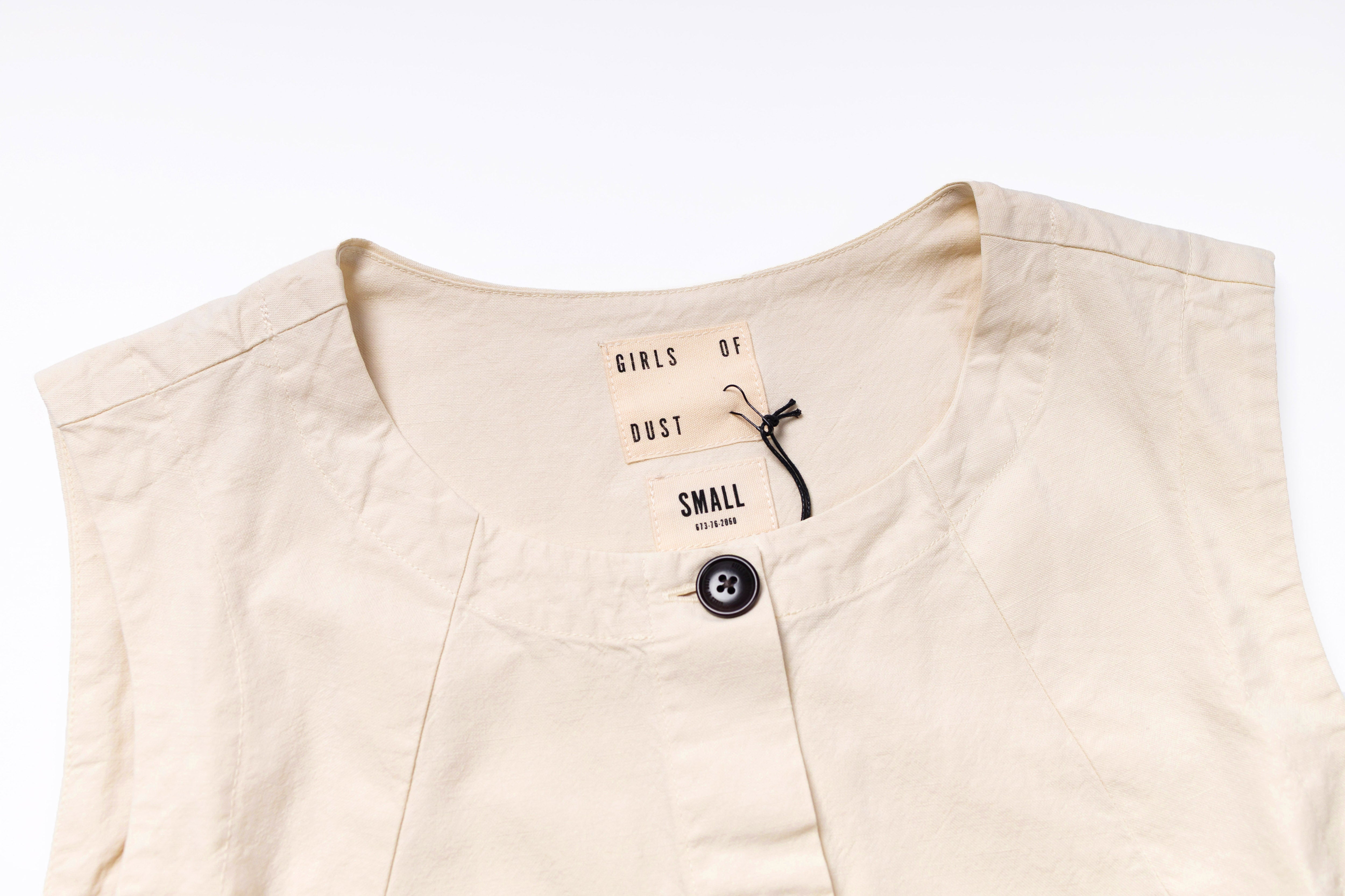 Beige sleeveless top with a tag on a white background
