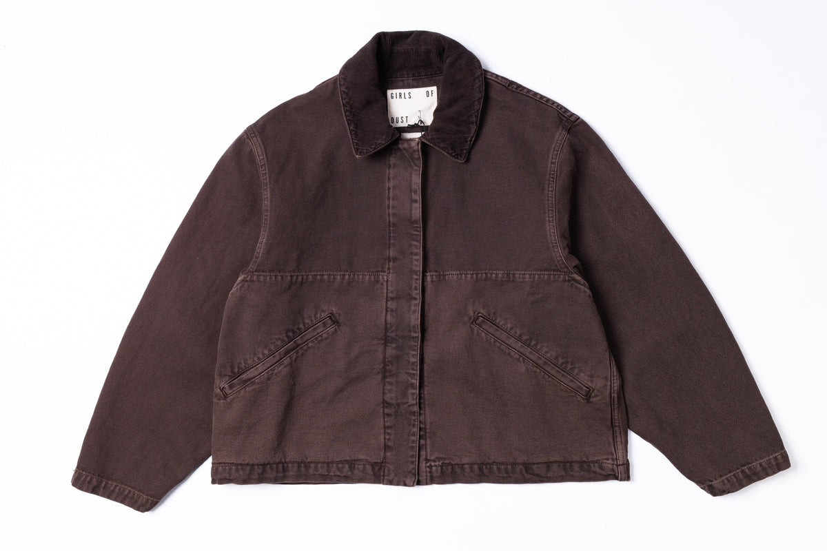 A dark brown corduroy jacket with a pointed collar, button-up front, and two diagonal welt pockets on the chest, laid flat against a white background.