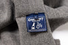 Close-up of a Guernsey Woollens label on a gray fabric background