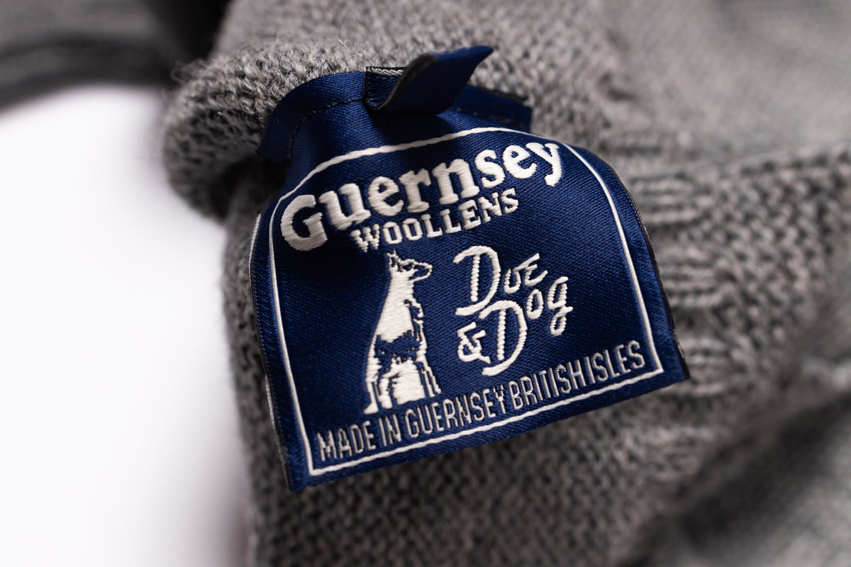 Close-up of a Guernsey Woollens label on a textured fabric background
