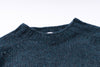 Close-up of a blue knitted sweater collar on a white background