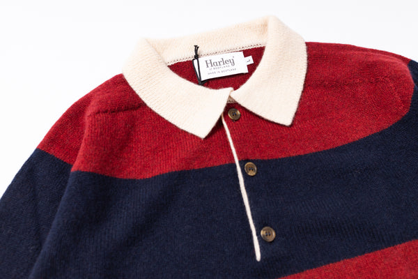 Close-up of a red and navy striped sweater with a white collar and Harley brand tag.