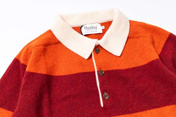 Close-up of a red and orange striped sweater with a white collar and Harley brand label.