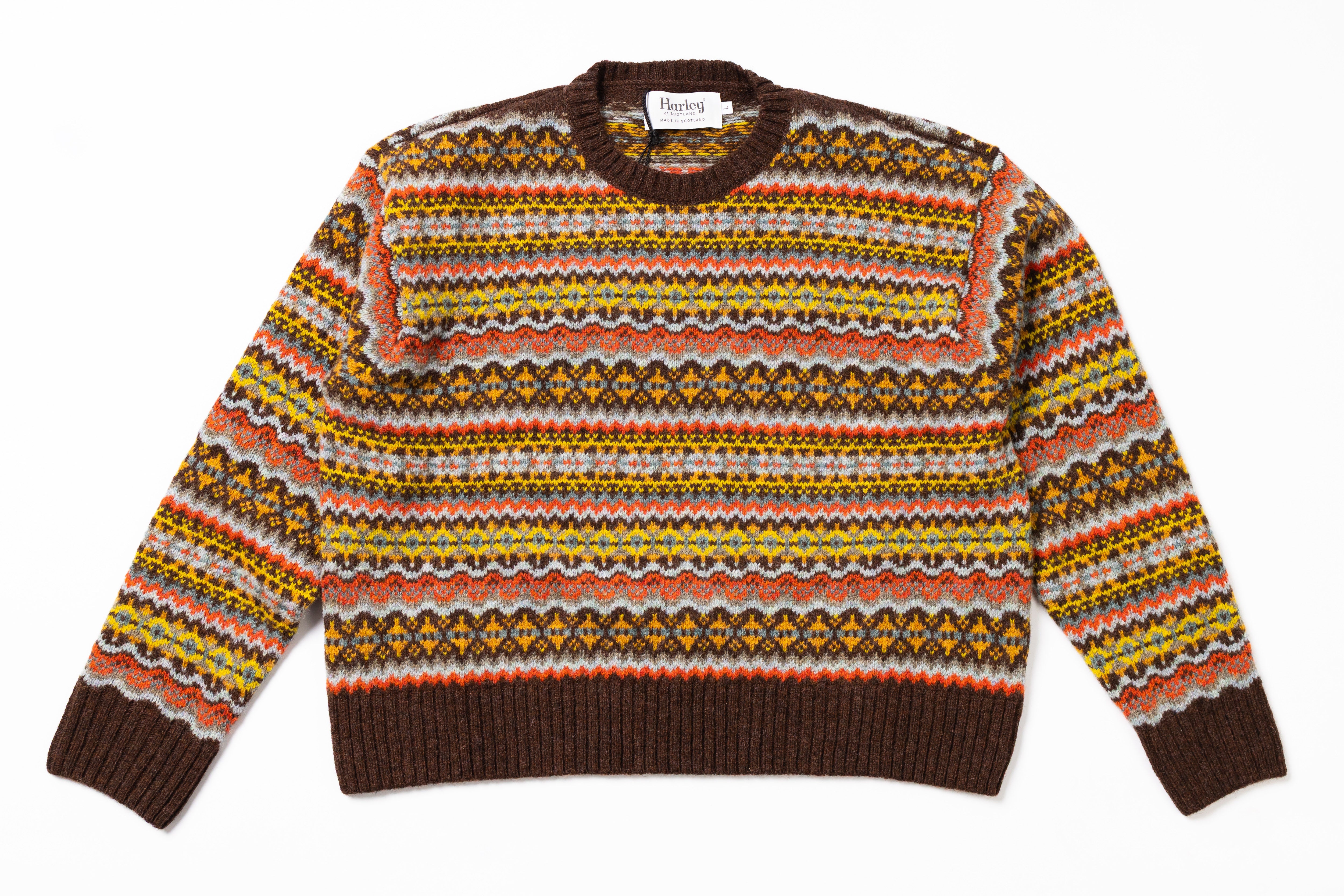 Patterned sweater with brown trim on a white background
