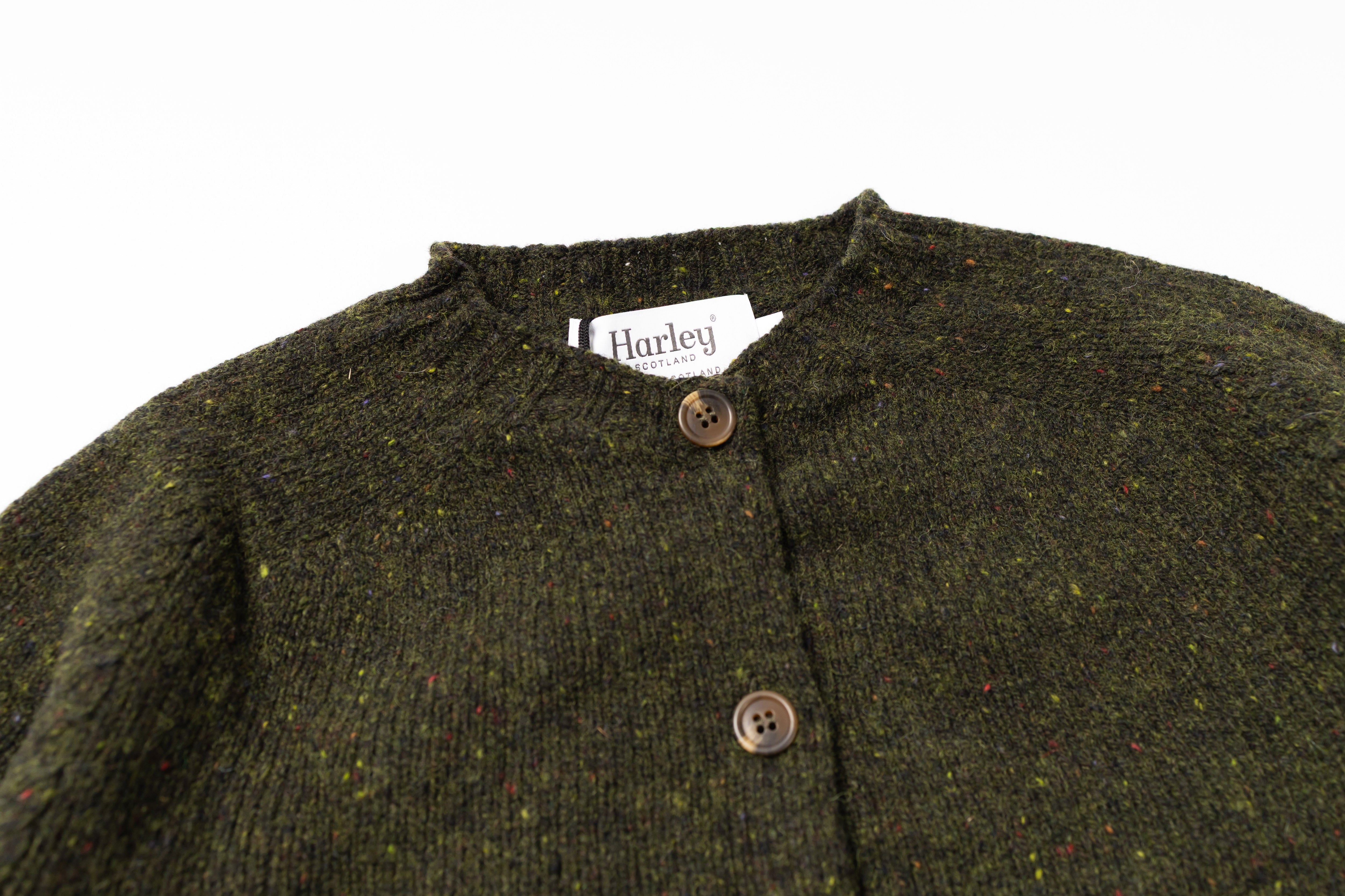 Close up on a collar of a green cardigan on a white background