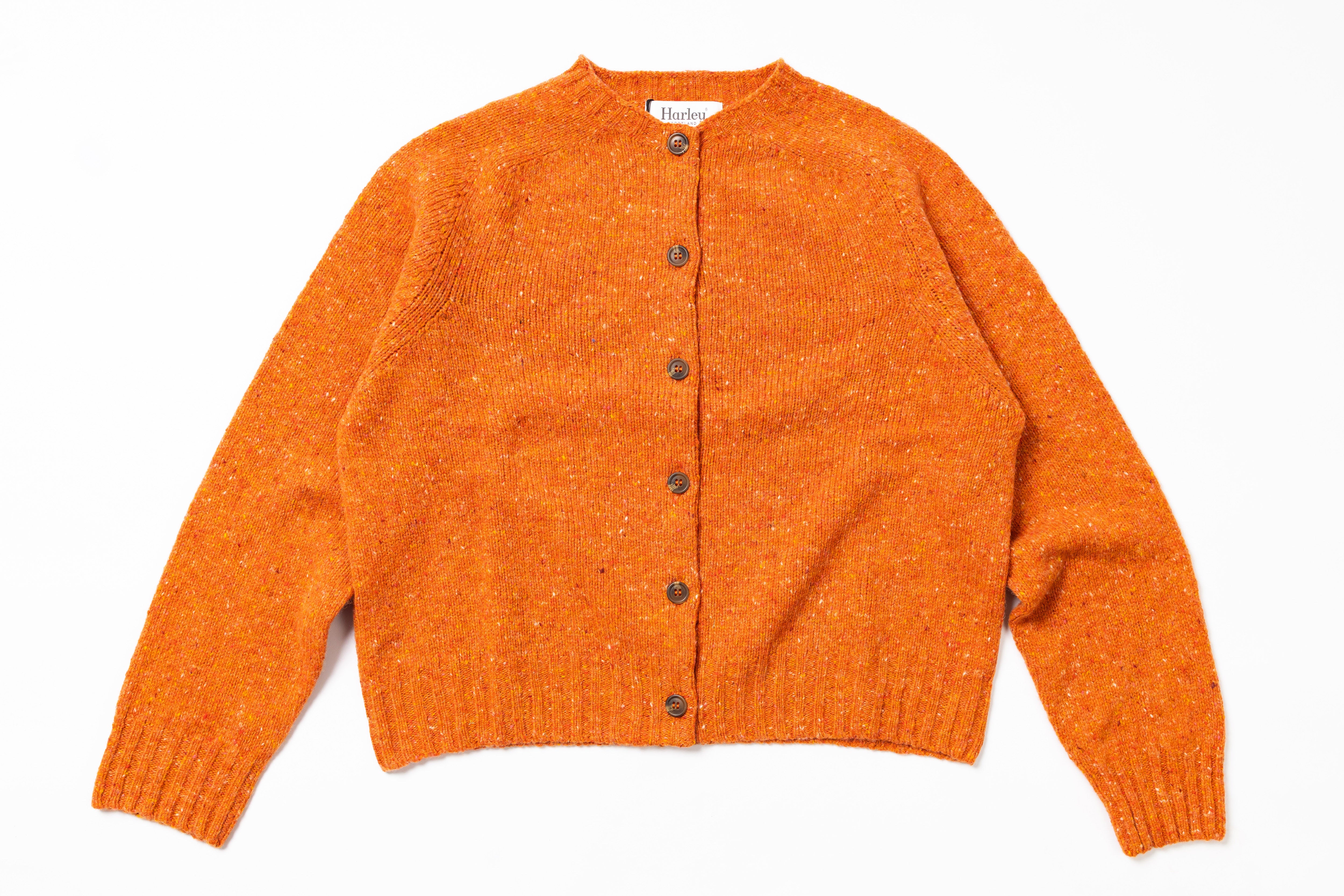 Orange knitted cardigan with buttons on a white background