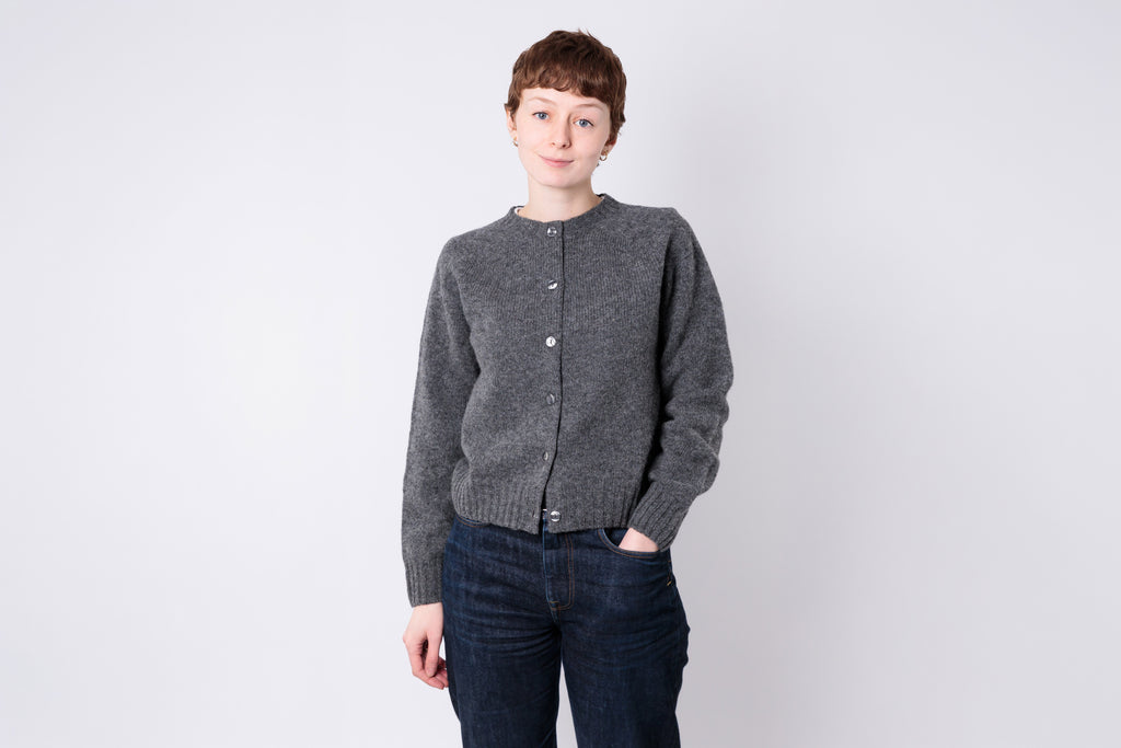 Woman wearing a grey cardigan on a white background