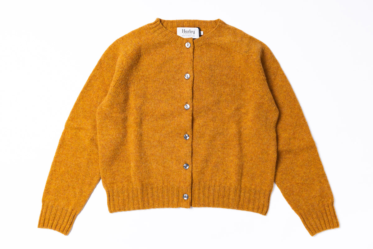 A mustard yellow knit cardigan sweater with a button-up front, laid flat on a white background. 
