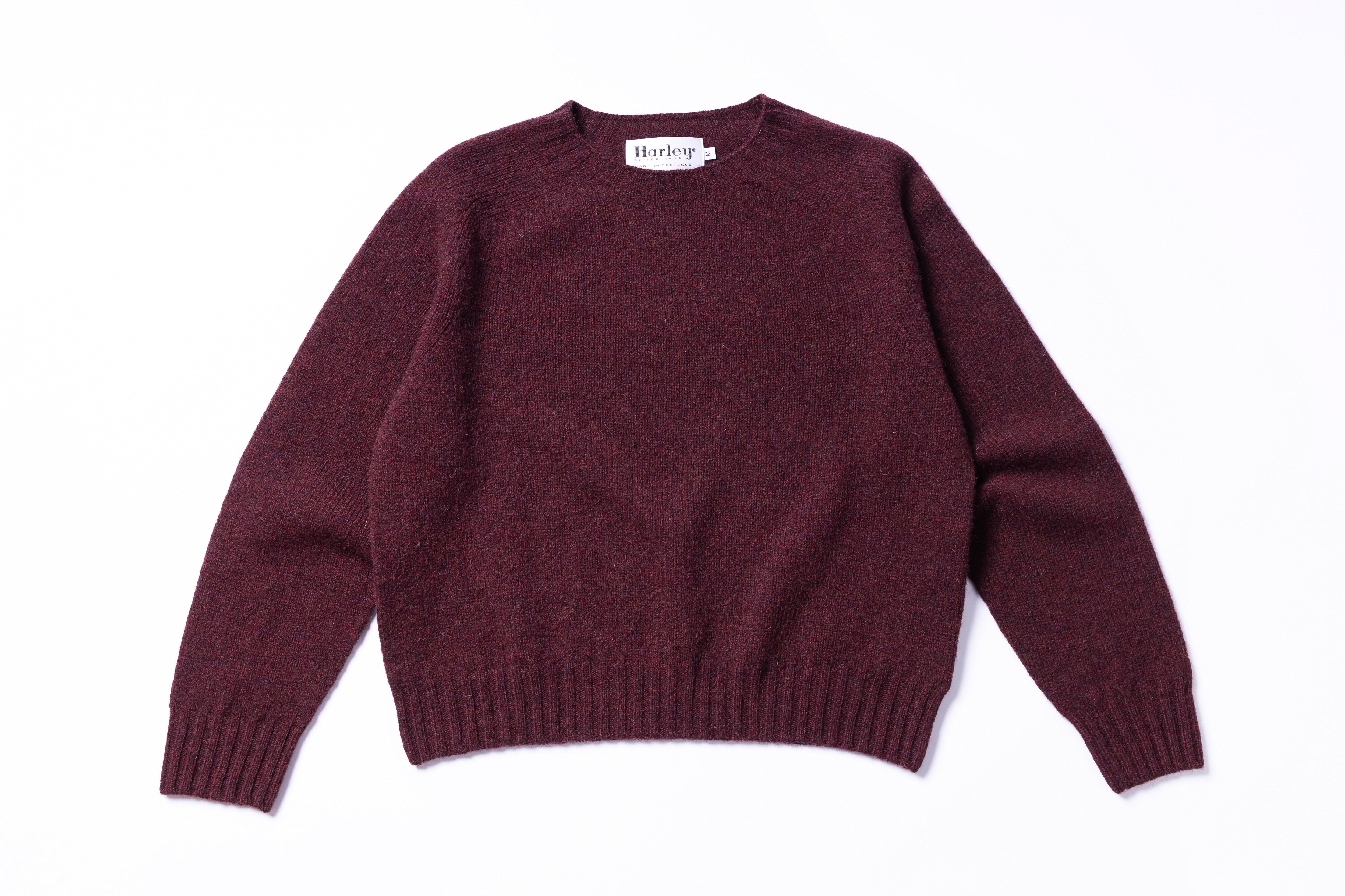 Maroon sweater with a brand label on a white background