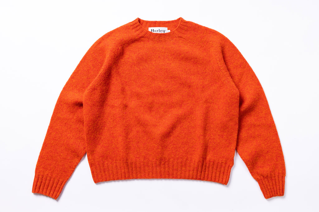Orange sweater with 'Harley' label on a white background