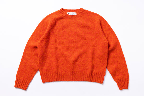 Orange sweater with 'Harley' label on a white background
