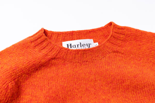 Light blue sweater with 'Harley' label on a white background zoomed in