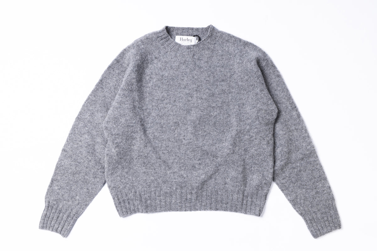 A light gray heathered knit crewneck sweater with long sleeves and ribbed cuffs and hem, laid flat on a white background.