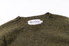 Green sweater collar with 'Harley' label on a white background
