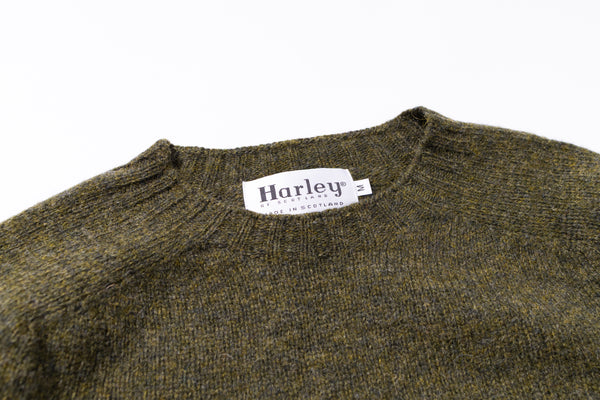 Green sweater collar with 'Harley' label on a white background