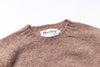 Brown sweater with 'Harley' label on a white background zoomed in
