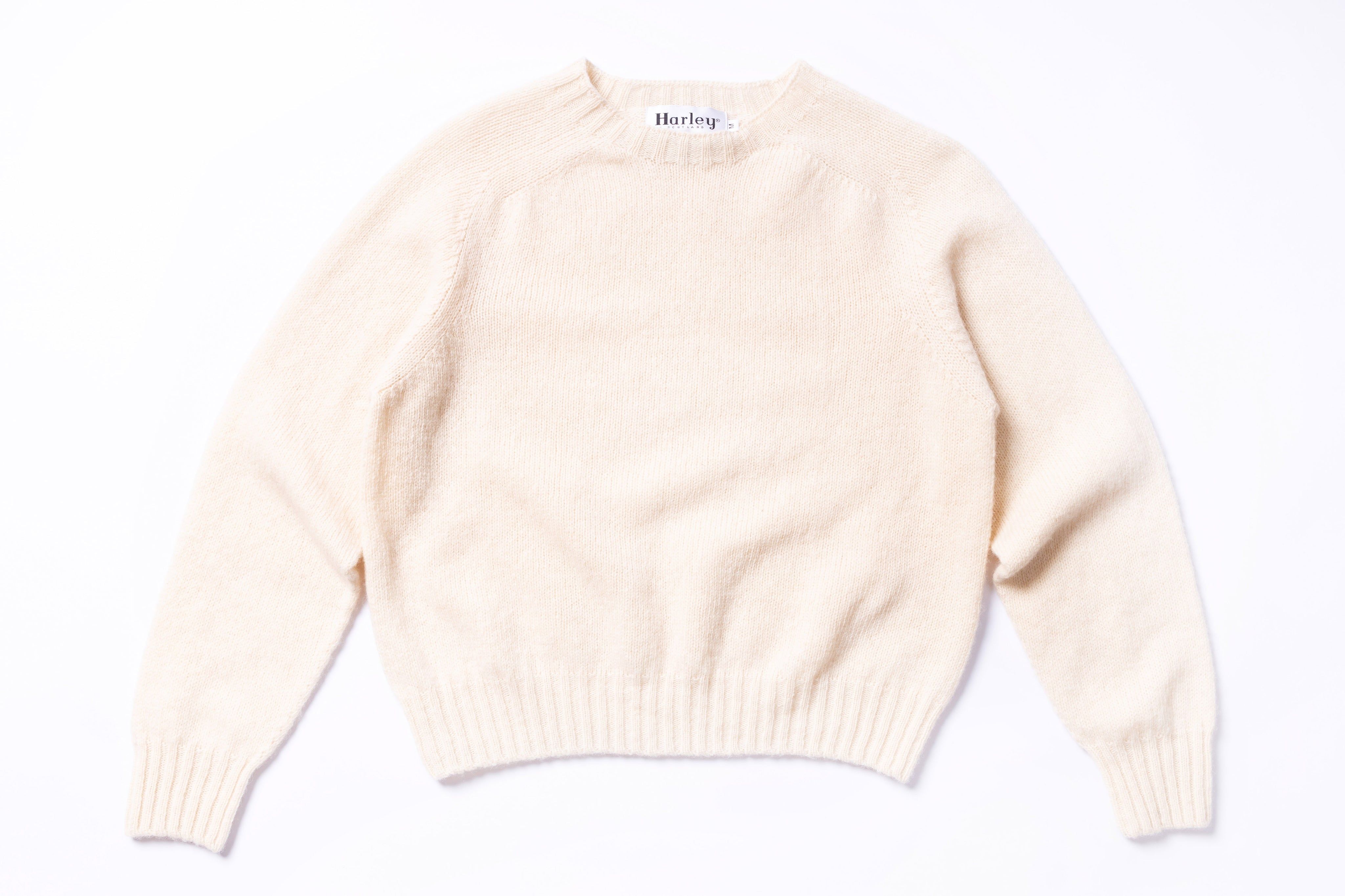 Beige sweater with  branding on a white background