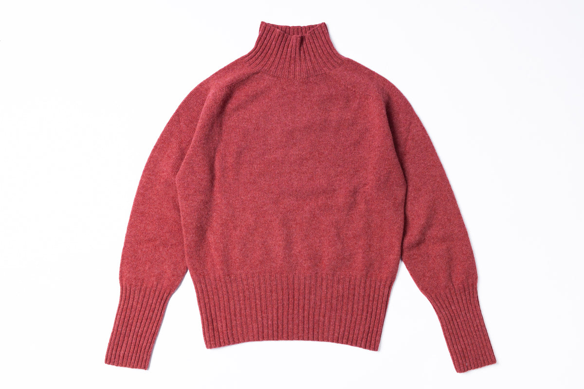 A heathered red knit turtleneck sweater with long sleeves and ribbed cuffs and hem, laid flat against a white background.
