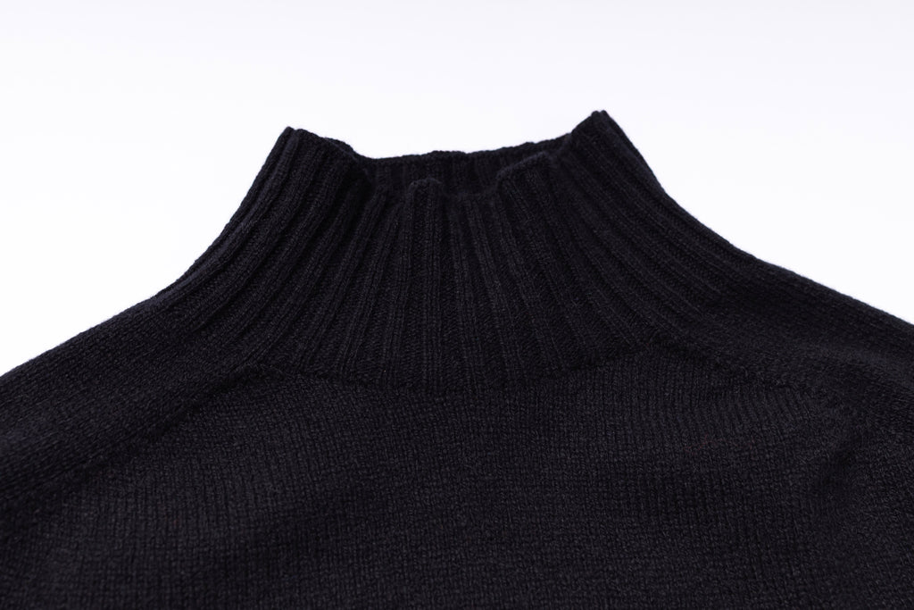 Close-up of a black turtleneck sweater on a white background