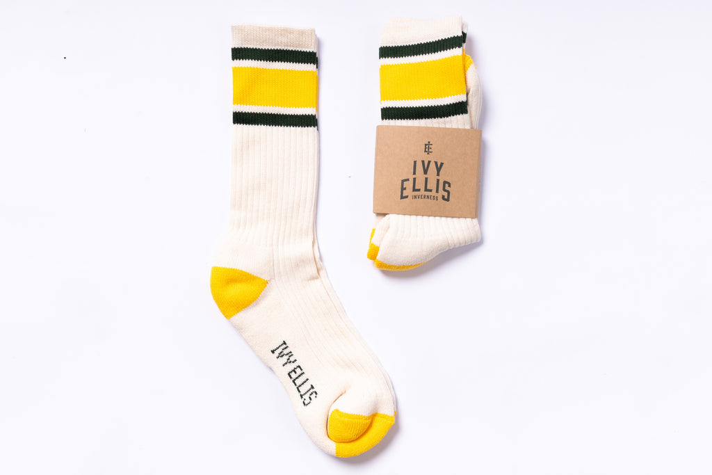 Pair of socks with yellow accents and 'Ivy Ellis' branding on a white background