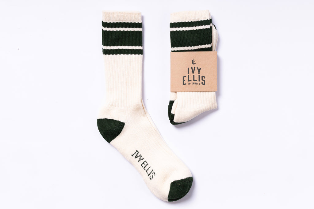Pair of white socks with green stripes and 'Ivy Ellis' branding on a white background.