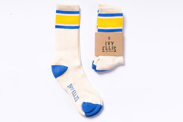 Pair of socks with yellow and blue stripes on a white background, featuring the brand 'Ivy Ellis'.