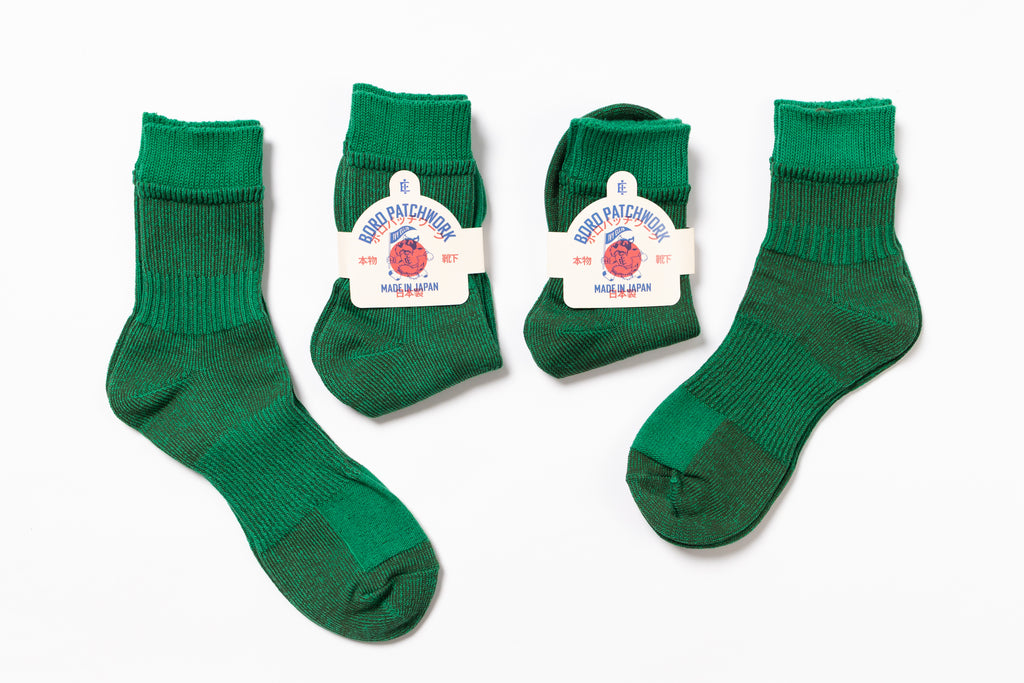 Four pairs of Green socks with labels on a white background